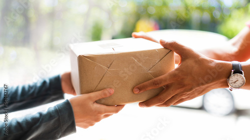 Hands of woman receiving parcel. Delivery man service sending boxes product at the door. Express delivery service. Online shopping at home.