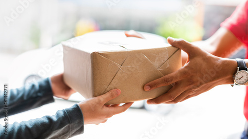 Hands of woman receiving parcel. Delivery man service sending boxes product at the door. Express delivery service. Online shopping at home.
