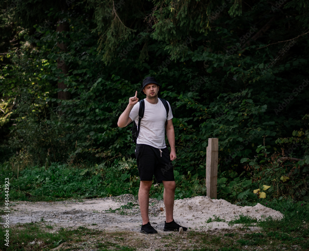 The guy shows a thumb up o the background of the forest The guy shows a thumb up o the background of the forest