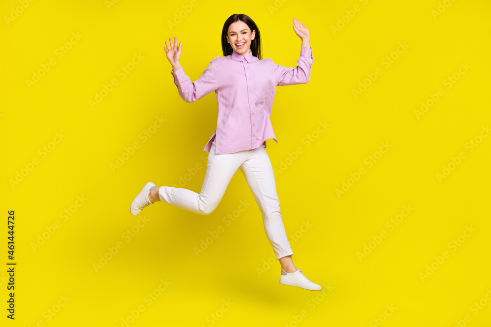 Full body photo of funky brown hairdo young lady run arms up wear pink shirt pants isolated on yellow color background