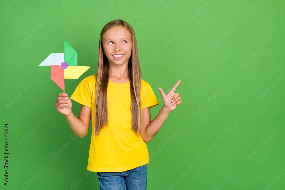 Portrait of attractive cheerful girl holding fan showing copy space isolated over vibrant green color background Portrait of attractive cheerful girl holding fan showing copy space isolated over vibrant green color background
