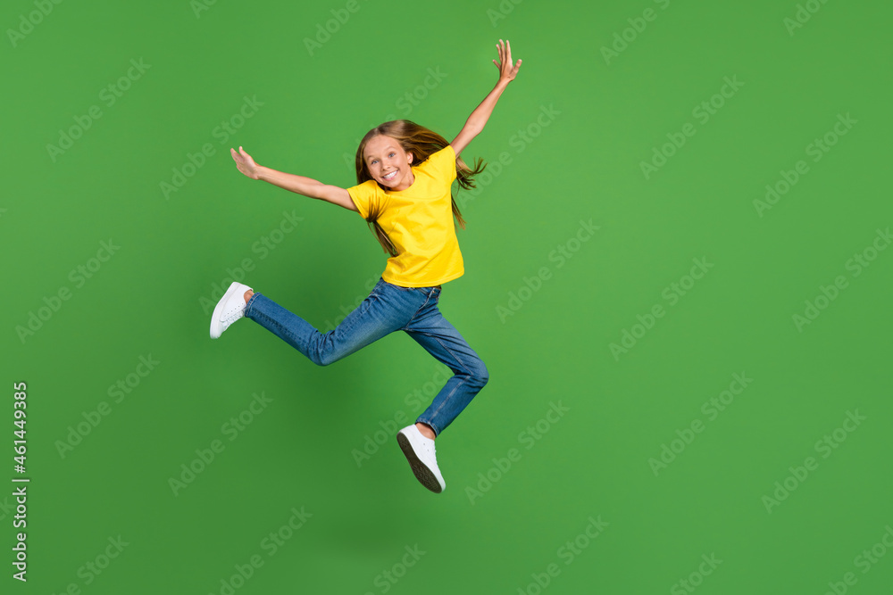 Full length body size view of attractive cheerful girl jumping having fun isolated over vivid green color background Full length body size view of attractive cheerful girl jumping having fun isolated over vivid green color background
