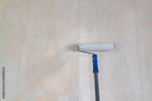 Primed with a roller with a primer putty wall before painting or gluing wallpaper