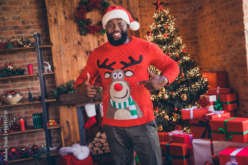 Photo of cheerful happy afro american man point finger sweater christmas deer indoors inside house home apartment photo