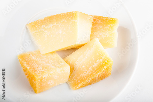 Parmesan cheese to add to pizza on a white plate