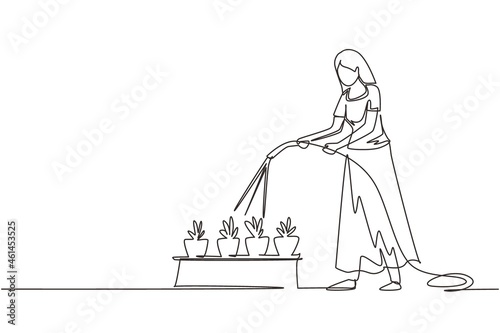 Continuous one line drawing young woman watering potted plants with hose. Gardening, greenhouse, botanical garden, flowers growing, plant nursery concept. Single line draw design vector illustration