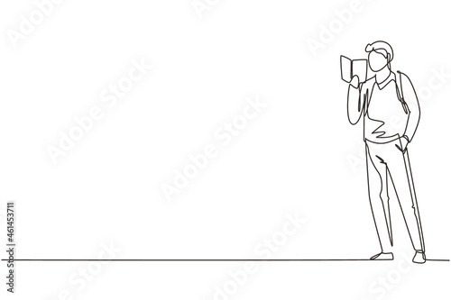 Continuous one line drawing guy standing and reads book that holds in one hand. Young man love to read. Male students with open books in hands. Single line draw design vector graphic illustration