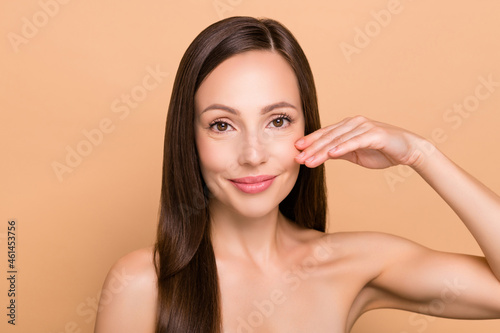 Photo of shiny pretty mature woman naked shoulders arm cheek smiling isolated beige color background