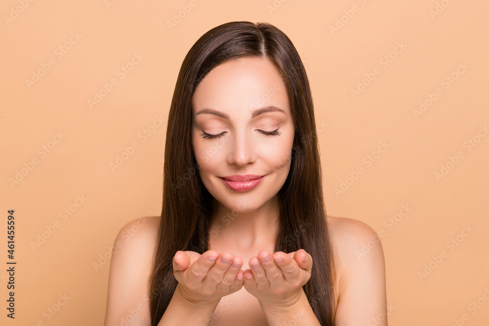 Portrait of attractive dreamy healthy woman washing clear clean flawless skin isolated over beige pastel color background