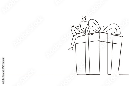 Single one line drawing businessman sitting on big gift box. Big present concept. Man sitting on big box with present. Happy person gets a huge gift. Continuous line draw design vector illustration
