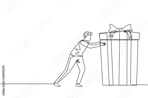 Single continuous line drawing young man pushes in front of him huge gift . Giving gifts for holiday concept. Wrapped birthday gift box with bow. Present, gift, birthday. One line draw design vector
