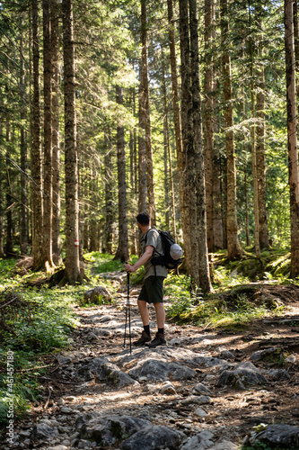 Junger Mann macht Pause vom wandern durch den Wald in der Natur in Österreich