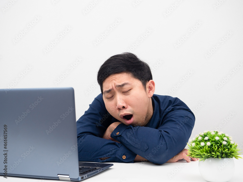 Man gesture yawn feeling sleepy tried from working with laptop on the table