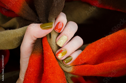 CloseUp top view of beautiful faded colors trendy manicure of green and beige glossy nails. Winter or autumn style of nail design concept
