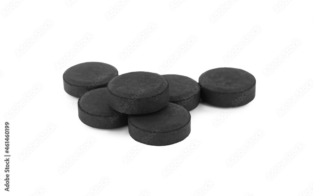 Activated charcoal pills on white background. Potent sorbent Activated charcoal pills on white background. Potent sorbent