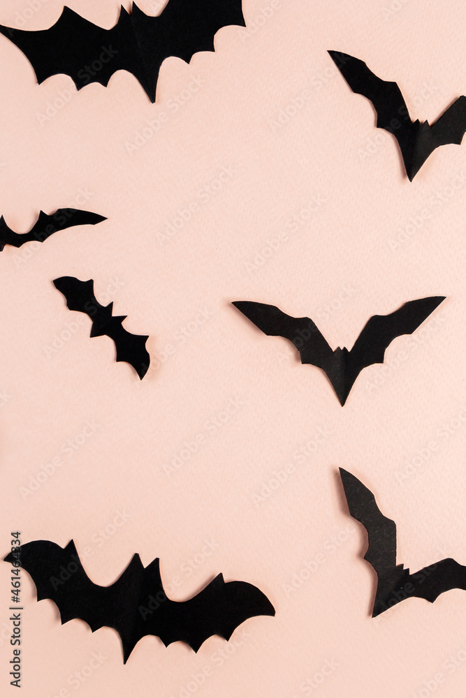 Halloween concept. Bats and spiders on pink background. Festive decorations.
