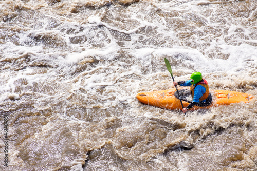 a rower on a kayak goes along a mountain river. dangerous active rest on the river