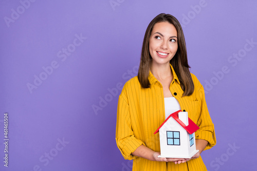 Photo of cute millennial brunette lady sell flat wear yellow shirt isolated on purple background