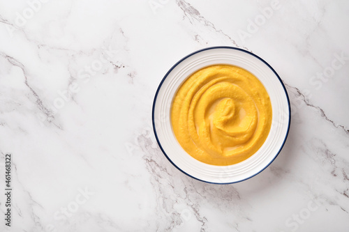 Pumpkin traditional soup with creamy silky texture with sage leaves and red pepper in white plate or bowl. Light grey background. Copy space. Mock up. Top view, flat lay.