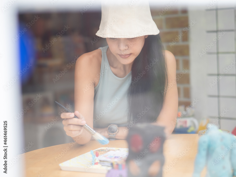 Young asian woman artist painting at home creative take picture through window. Selective focus Young asian woman artist painting at home creative take picture through window. Selective focus