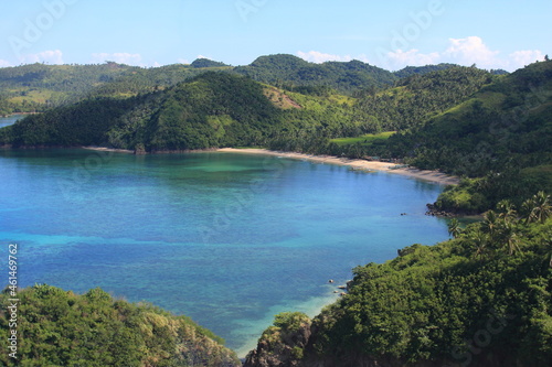 aerial view of a small beach and surrounding mountains and ocean in the Philippines