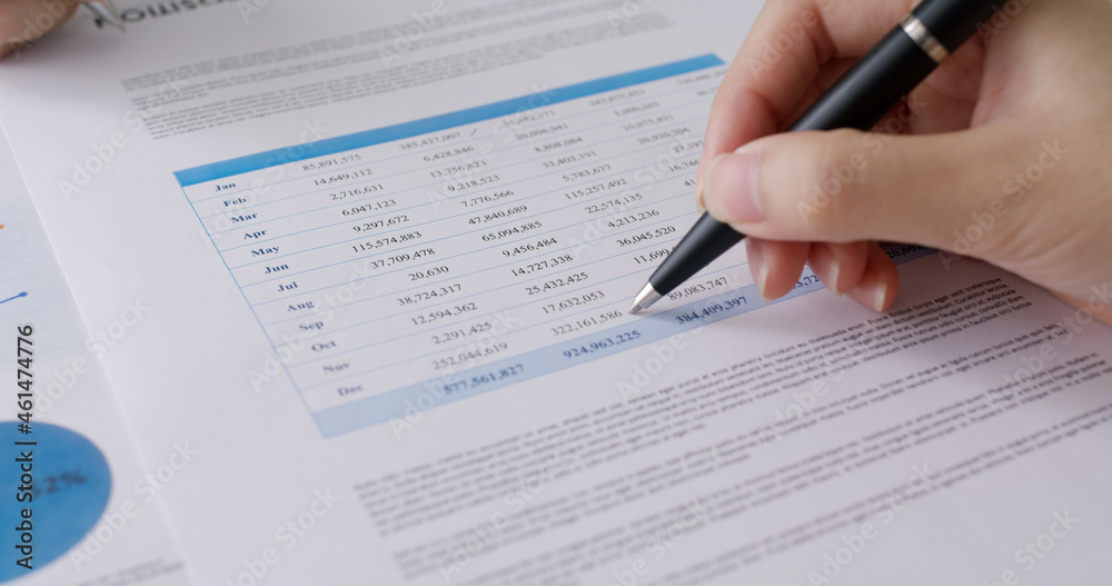 Stock trader agent or MBA student learn tax wealth working at lawyer office use pen in hand checking data table mark income growth number in month budget money plan report sheet. Bank loan risk audit.