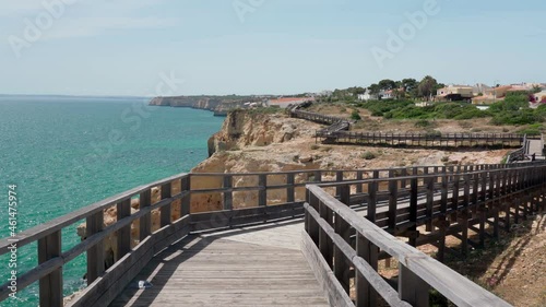 Wonderful view of the Portuguese coast of Carvoeiro in summer, walking along the wooden paths. Overlooking the blue sea. Shooting in motion with a stabilizer.
