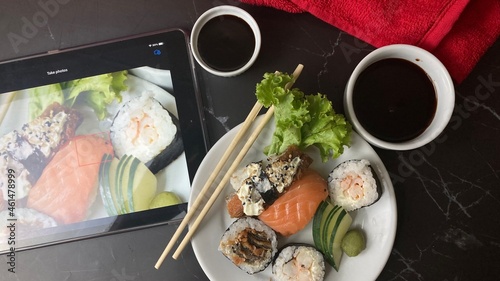 A sushi é uma refeição japonesa tradicional que é feita de arroz cozido e temperado com vinagre, algas e outros ingredientes. As características  são os seus pequenos tamanhos e a forma como é servido photo