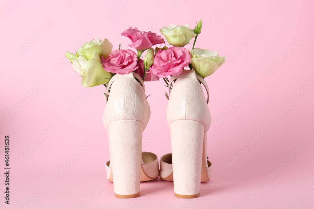 Stylish women's high heeled shoes with beautiful flowers on pink background Stylish women's high heeled shoes with beautiful flowers on pink background
