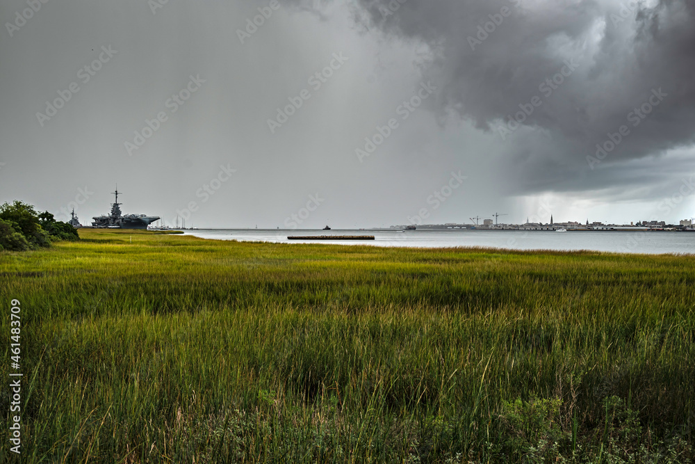 Rapidly moving rain storm over Charleston Harbor, with USS Yorktown at left and storm clouds overhead.