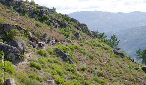 Grupo de pessoas a fazer uma caminhada pela encosta de uma montanha - trilho montanhoso - dia quente de verão photo