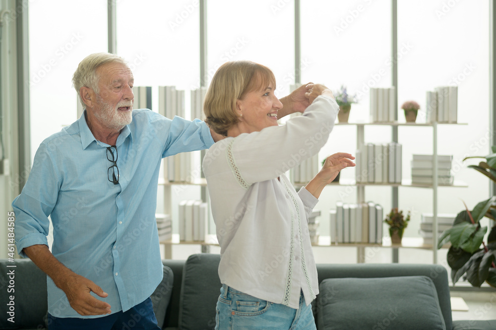 Obraz premium Happy Caucasian senior couple dancing at home