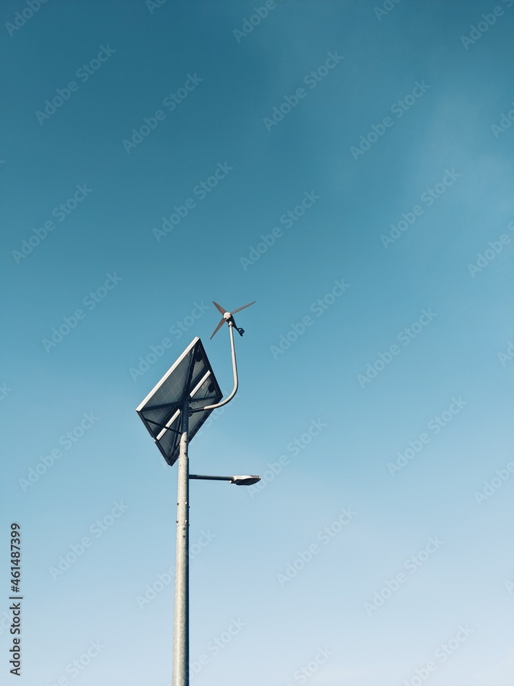 Street lamp on the blue sky, wind turbine and solar panel