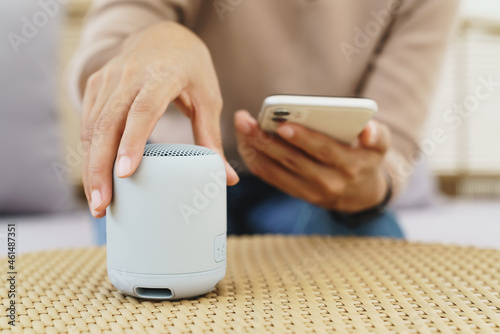 close-up on hand using phone connecting speaker bluetooth photo