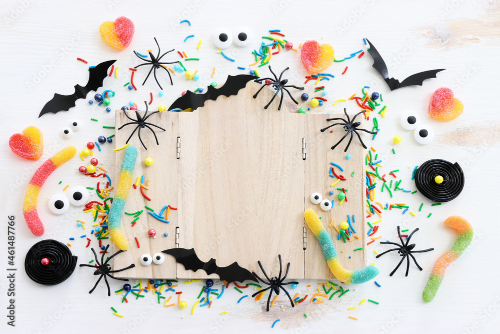 holidays image of Halloween. spiders, bats and wooden board frame for text or mock up over white wooden table