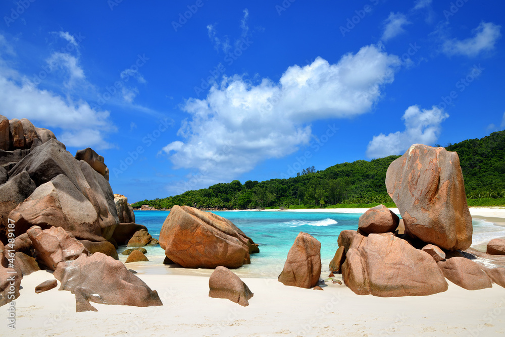 Anse Cocos beach with big granite stones in La Digue Island, Indian Ocean, Seychelles. Tropical landscape with sunny sky. Exotic travel destination.