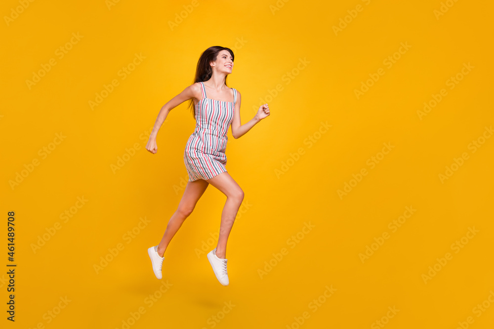 Full length body size woman smiling jumping high happy running fast isolated vivid yellow color background