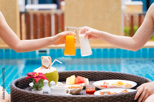 Closeup women enjoy floating breakfast in the luxury hotel resort. Female relaxing in summer vacation.