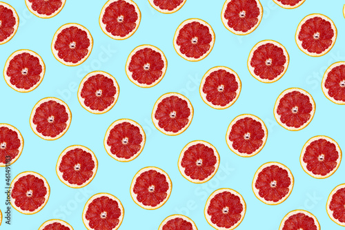 Fresh grapefuit slices seamless pattern over blue background, top view