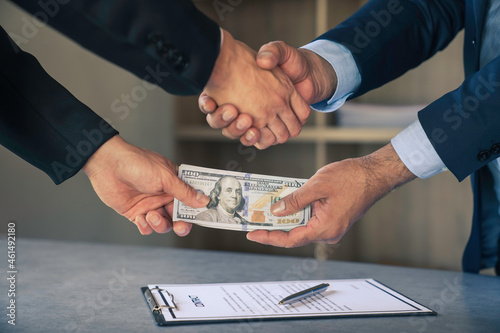 Businessmen or politicians agree to accept bribes. by shaking hands To do illegal business, corruption in the contracting business, corruption concept and bribery.