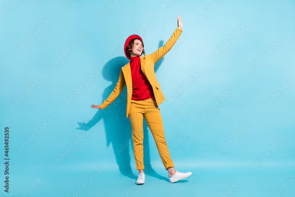 Full size photo of young cheerful girl happy positive smile wear suit look empty space isolated over blue color background