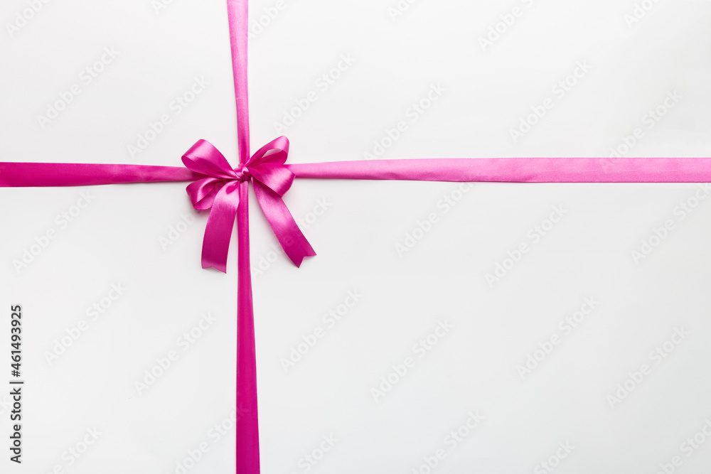 Top view of purple ribbon rolled and pink bow isolated on colored background. Flat lay with copy space Top view of purple ribbon rolled and pink bow isolated on colored background. Flat lay with copy space