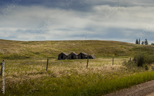 Rustic buildings and grain elevator stand in what used to be the town of Sharples Alberta Canada photo