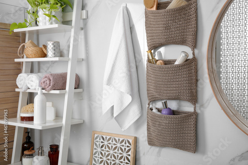 Knitted organizer hanging on wall in bathroom photo