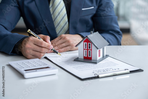 The real estate agent is reading and signing contracts for rent or purchase, inspects sample homes and Business contract, lease, purchase, mortgage, loan or home insurance documents
