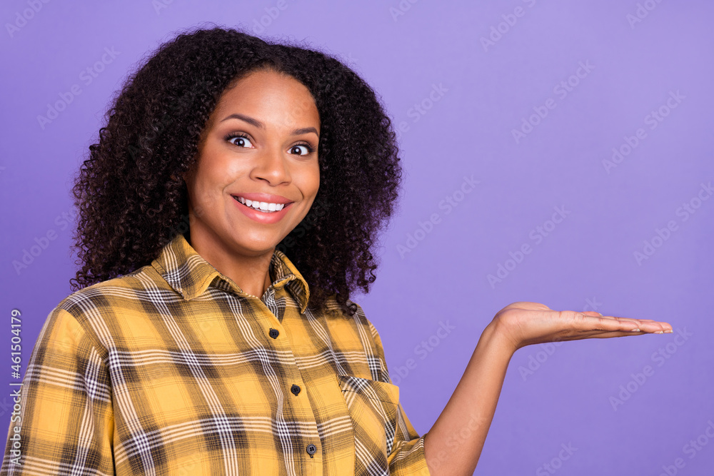 Photo of amazed happy afro american excited woman hold hand empty space offer isolated on purple color background