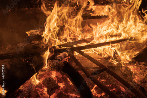 Old wooden crutches are burning in a large fire. Burning wood waste.