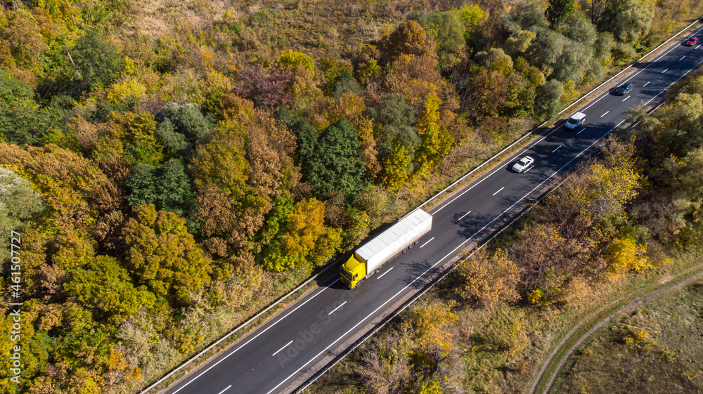 Aerial. Truck logistics aerial. Traffic motion by the countryside highway. View above from drone.