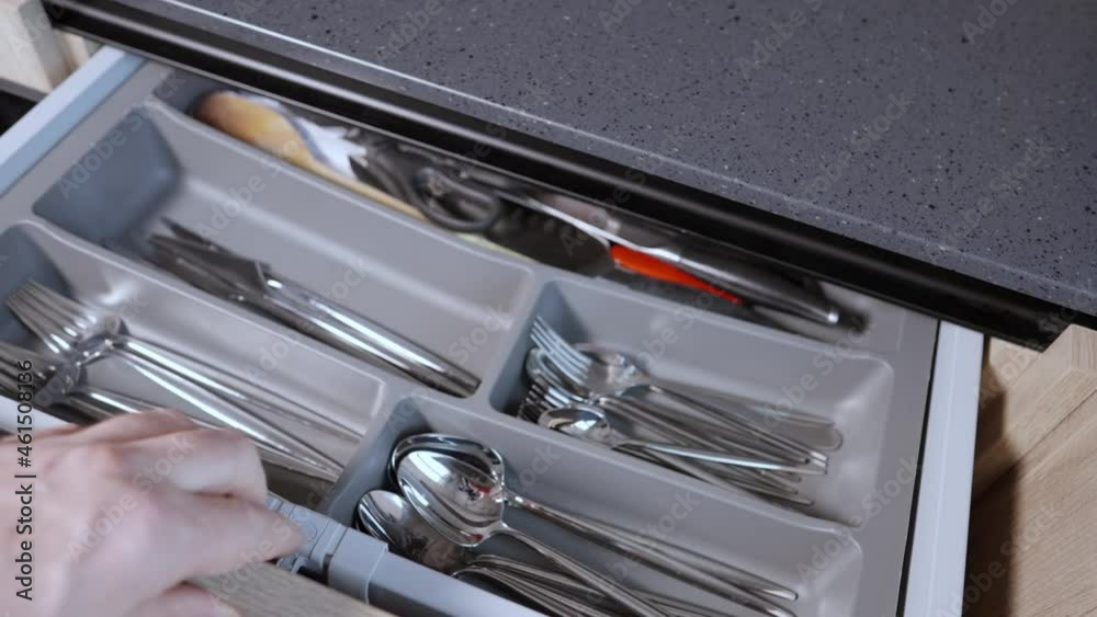 Hand of a person opening a cutlery storage drawer Hand of a person opening a cutlery storage drawer