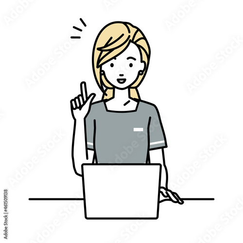 デスクで座ってPCを開いて何かひらめいたエステ店員の女性